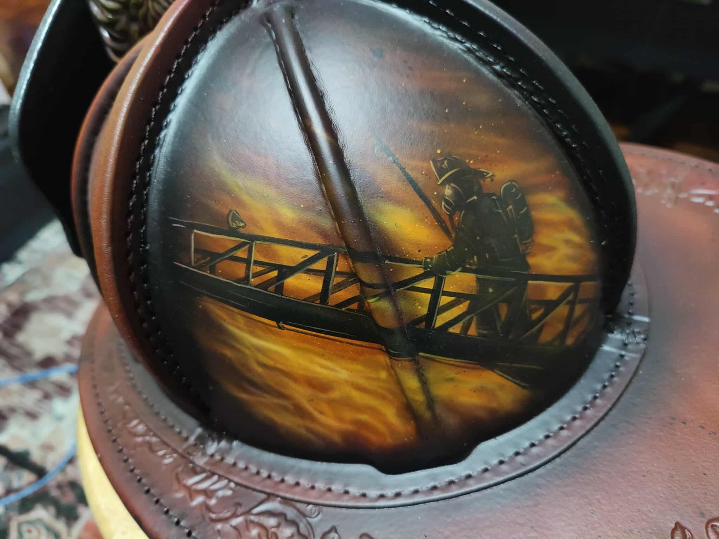 Brown leather helmet with firefighter ladder artwork